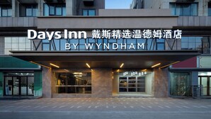The exterior of Days Inn by Wyndham, featuring a modern facade with large glass windows and a prominent entrance. - Days Inn by Wyndham Xi'an Yanliang (Xi'an)