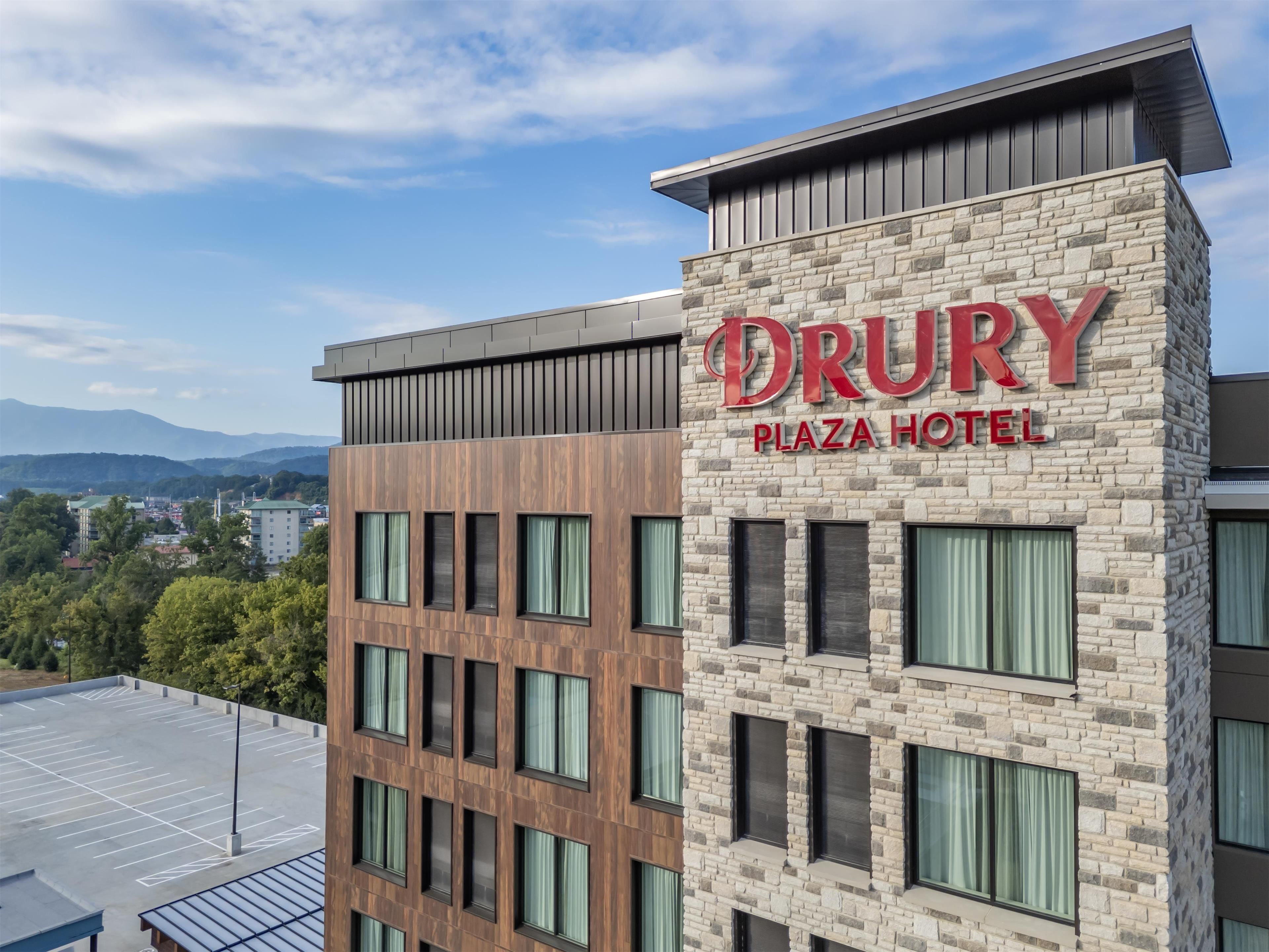 Het uiterlijk van het Drury Plaza Hotel, met een gevel van natuursteen en meerdere ramen.