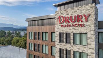 Het uiterlijk van het Drury Plaza Hotel, met een gevel van natuursteen en meerdere ramen.