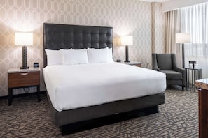Relax in this inviting room with a large bed, two bedside tables, and a comfortable armchair.