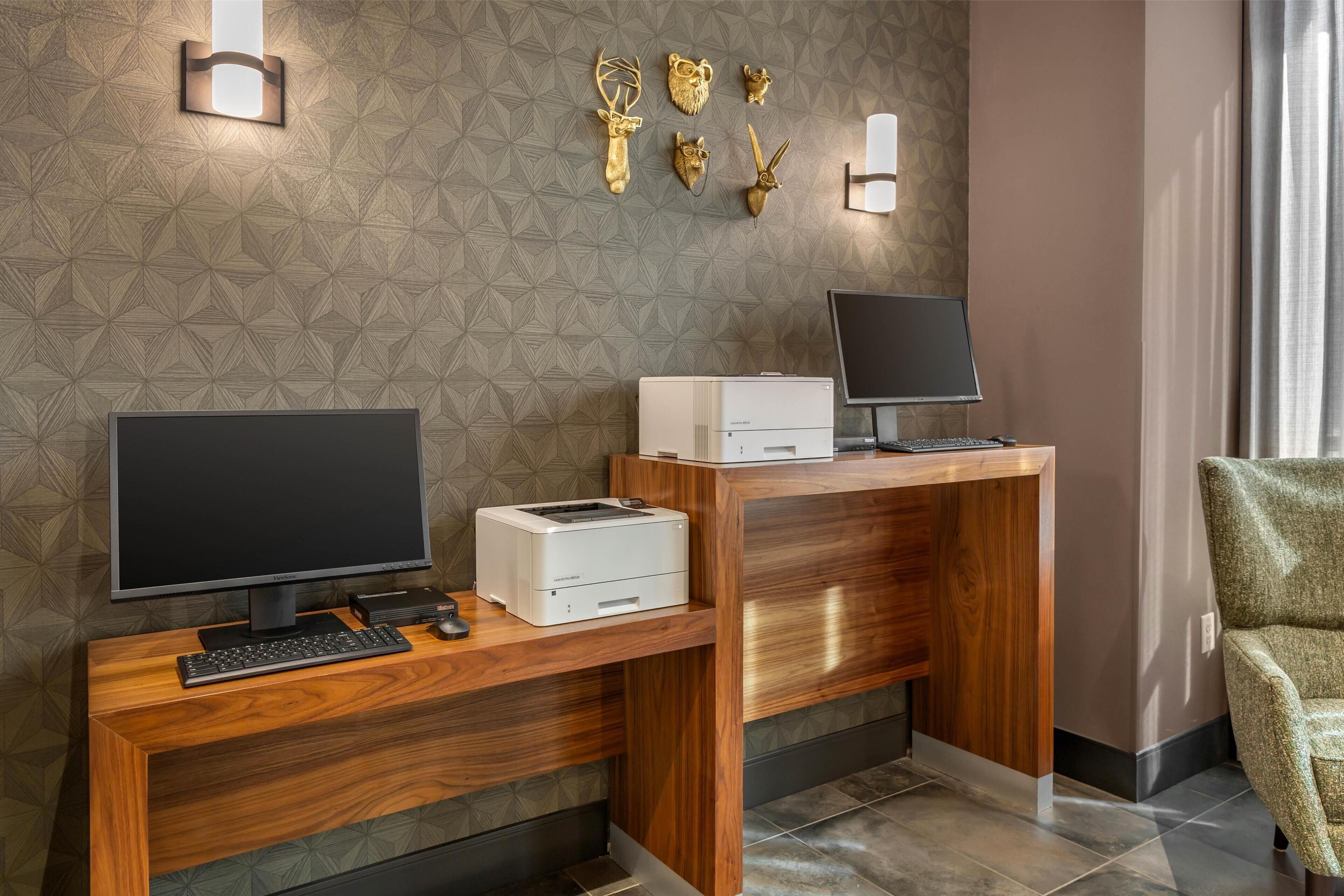 A modern office desk with a computer, printer, and keyboard.