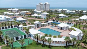 Ein Resort mit mehreren Gebäuden, einem Tennisplatz, einem Pool und Blick auf den Ozean.