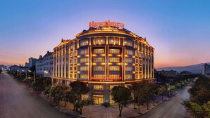 A hotel with a distinctive curved facade and illuminated signage.
