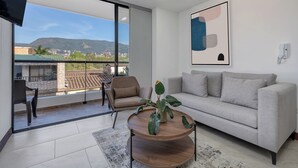 A modern living room with a sofa, a coffee table, and a TV.
