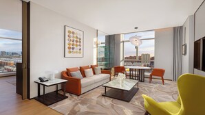 A modern living room with a sofa, coffee table, and chairs, a city view through large windows, and a framed artwork on the wall. - Holiday Inn Datong by IHG (Datong)