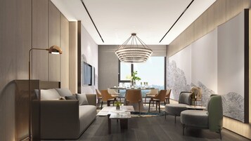 Una sala de estar moderna con sofá, mesa de centro y sillas, un comedor con candelabro, y un ventanal con vistas a la ciudad.