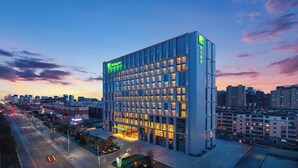 A Holiday Inn hotel with a modern design, featuring a large number of windows and a prominent green logo. - Holiday Inn Datong by IHG (Datong)