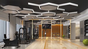 A modern gym with exercise equipment, a digital screen, and a wooden floor with measurement markings. - Holiday Inn Datong by IHG (Datong)