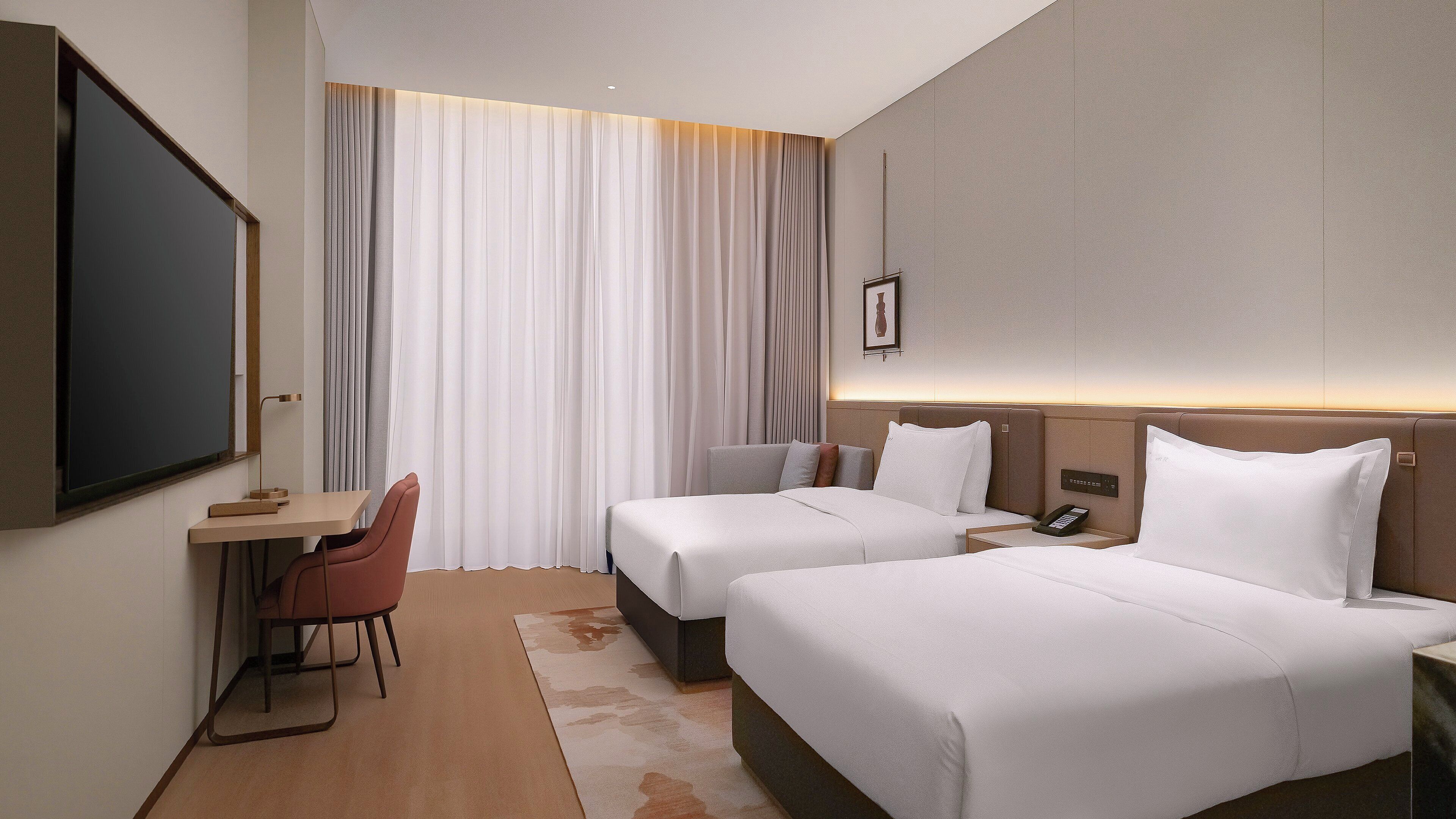Habitación de hotel con dos camas, un escritorio, una silla y un televisor.