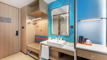 A modern bathroom with a large mirror, a sink, and a shower area.