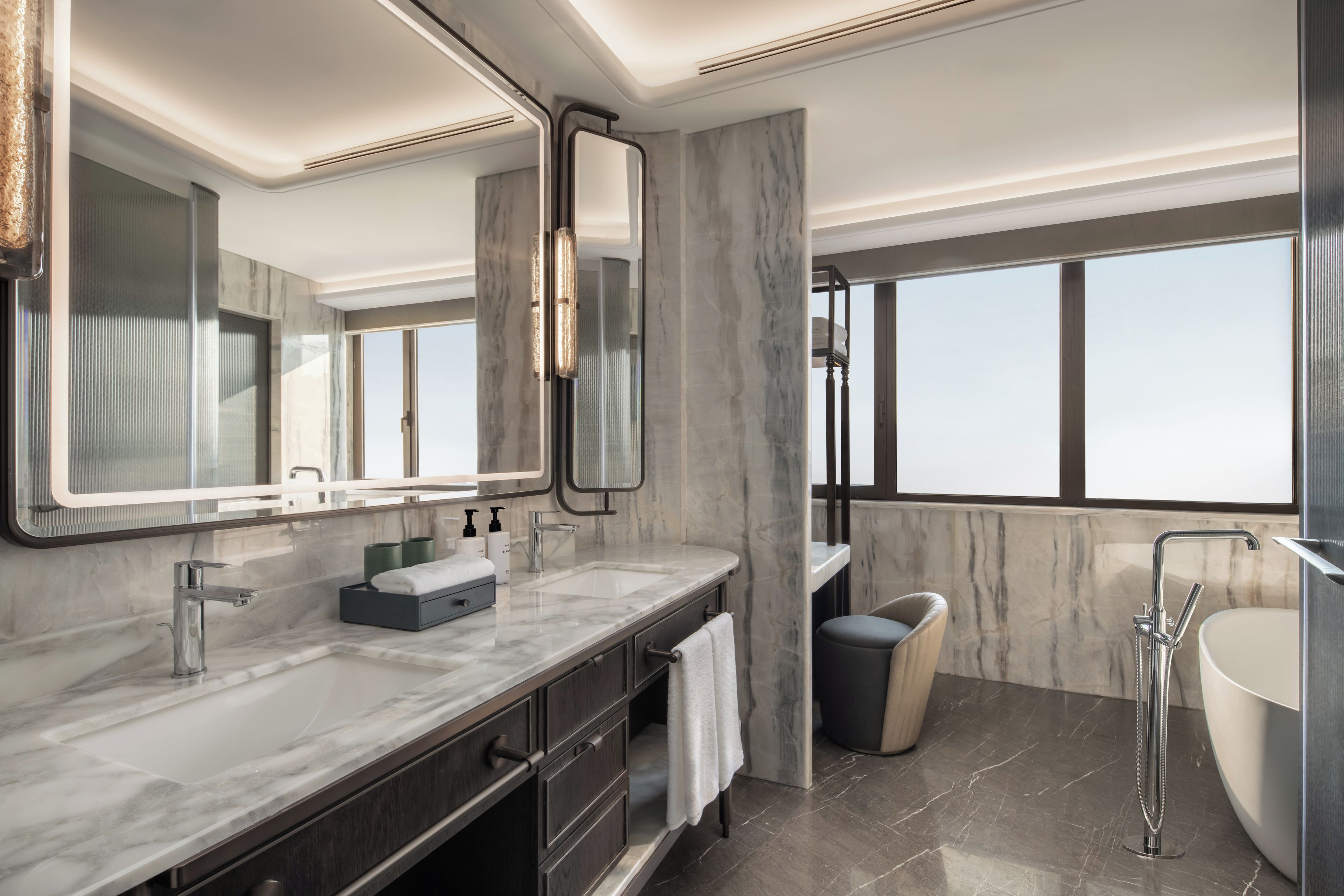 A modern bathroom with a large mirror, a bathtub, and a shower.