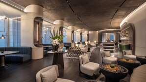 A modern interior with seating areas, a bar, and a view of the outdoors. - Intercontinental Hangzhou Wulin by IHG (Hangzhou)