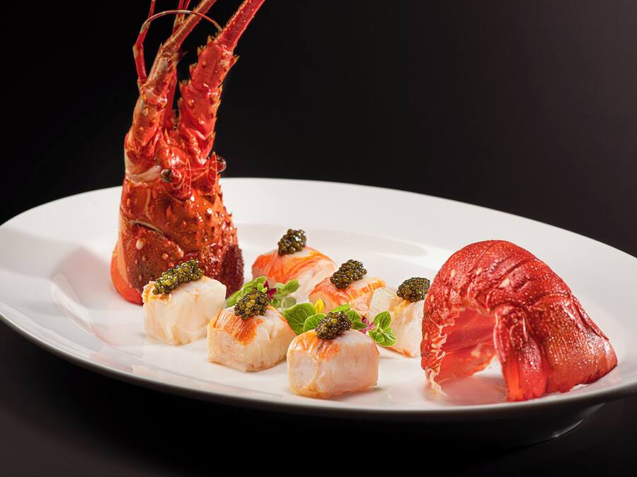 Ein Teller mit Hummer, Sashimi und Kaviar.