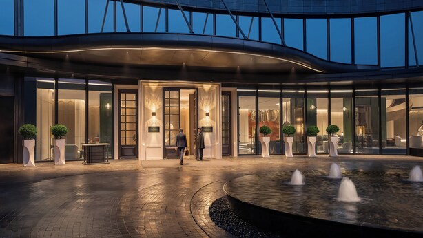 A modern hotel entrance with a curved facade, large windows, and a water feature in the foreground. - Intercontinental Hangzhou Wulin by IHG (Hangzhou)