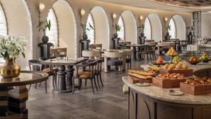A restaurant with round tables, chairs, and a buffet area with various food items. - Intercontinental Hangzhou Wulin by IHG (Hangzhou)