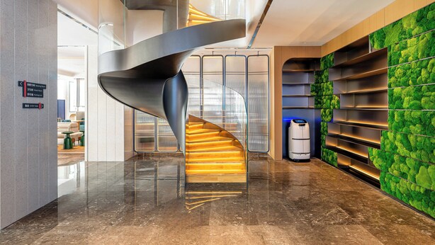 Un interior moderno con una escalera de caracol, una pared verde con textura y un suelo limpio y pulido.