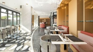 Un restaurante moderno con una zona de estar curva, una barra central y vistas al exterior.