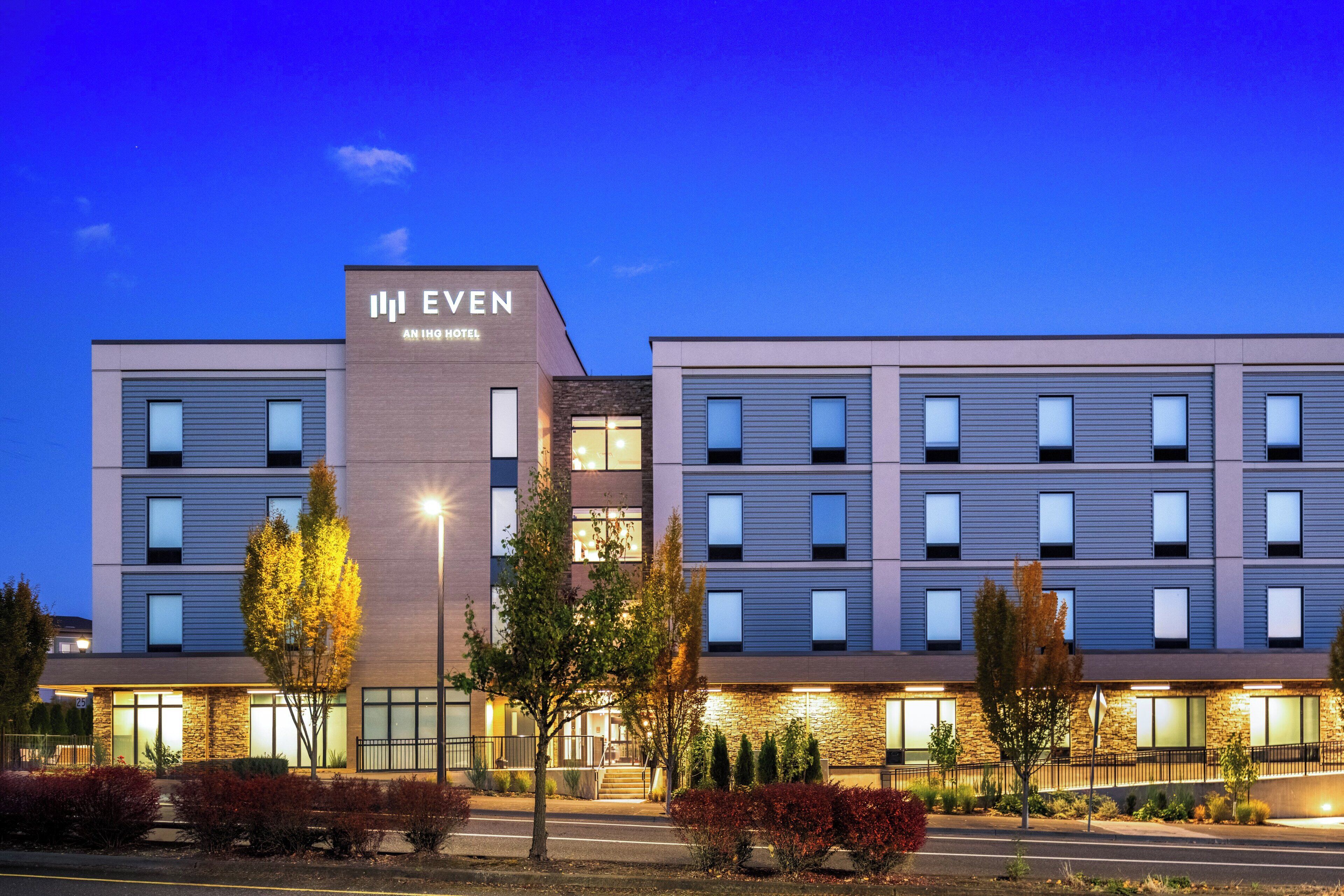 A modern hotel with a flat roof, multiple windows, and a sign that reads "EVEN ANHQ HOTEL".