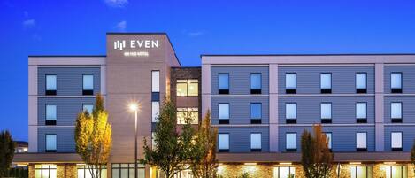 A modern hotel with a flat roof, multiple windows, and a sign that reads "EVEN ANHQ HOTEL".
