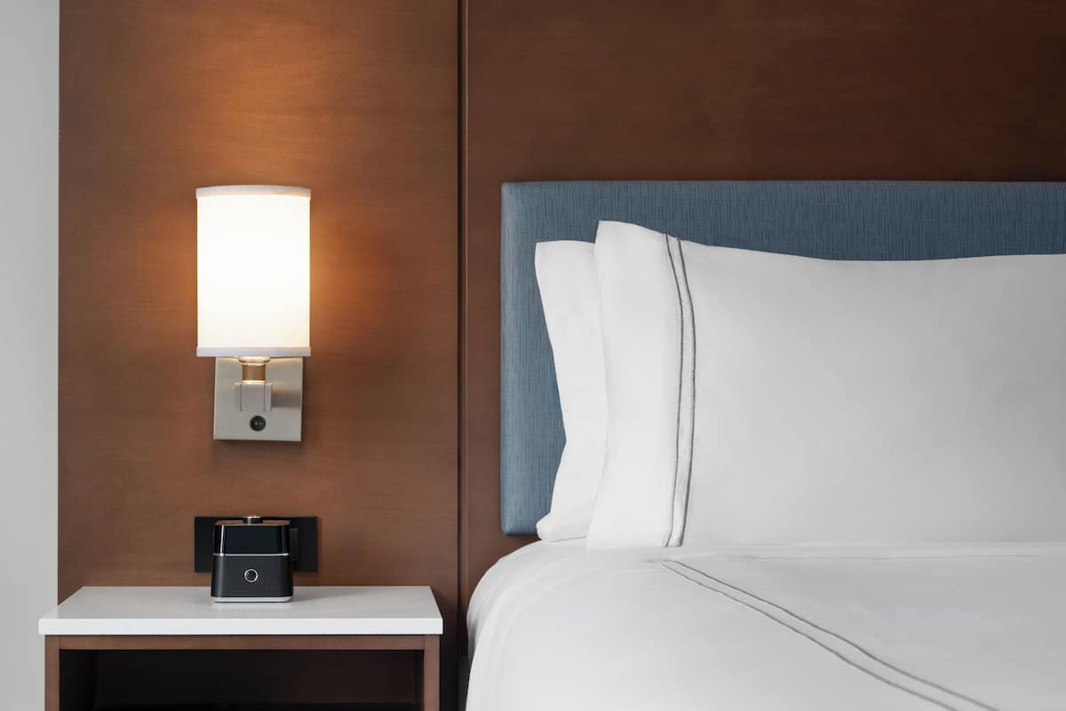Roupas de cama premium, escrivaninha, espaço de trabalho para notebook