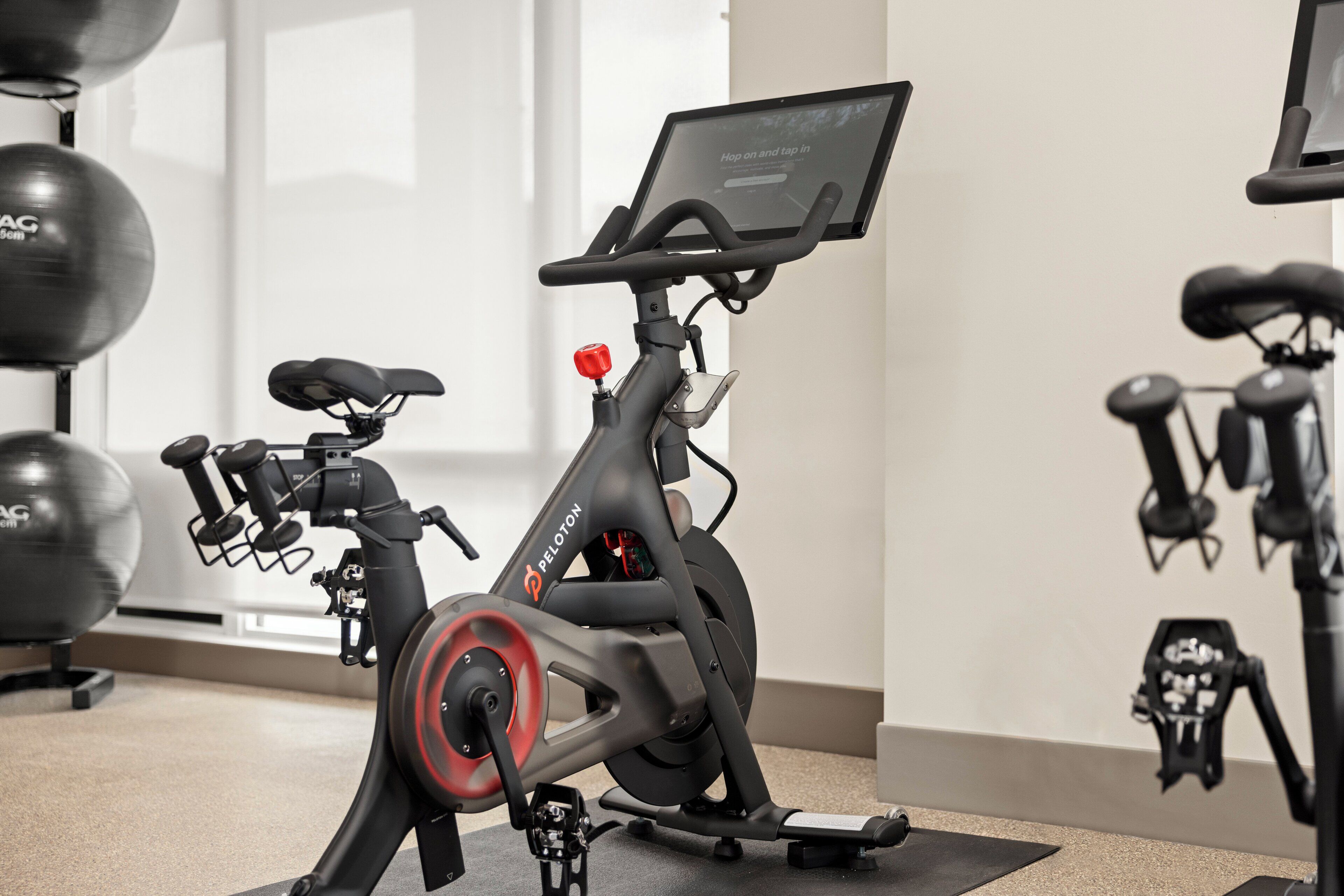 Un vélo d’appartement doté d’un écran numérique, d’un bouton rouge et d’une selle noire.