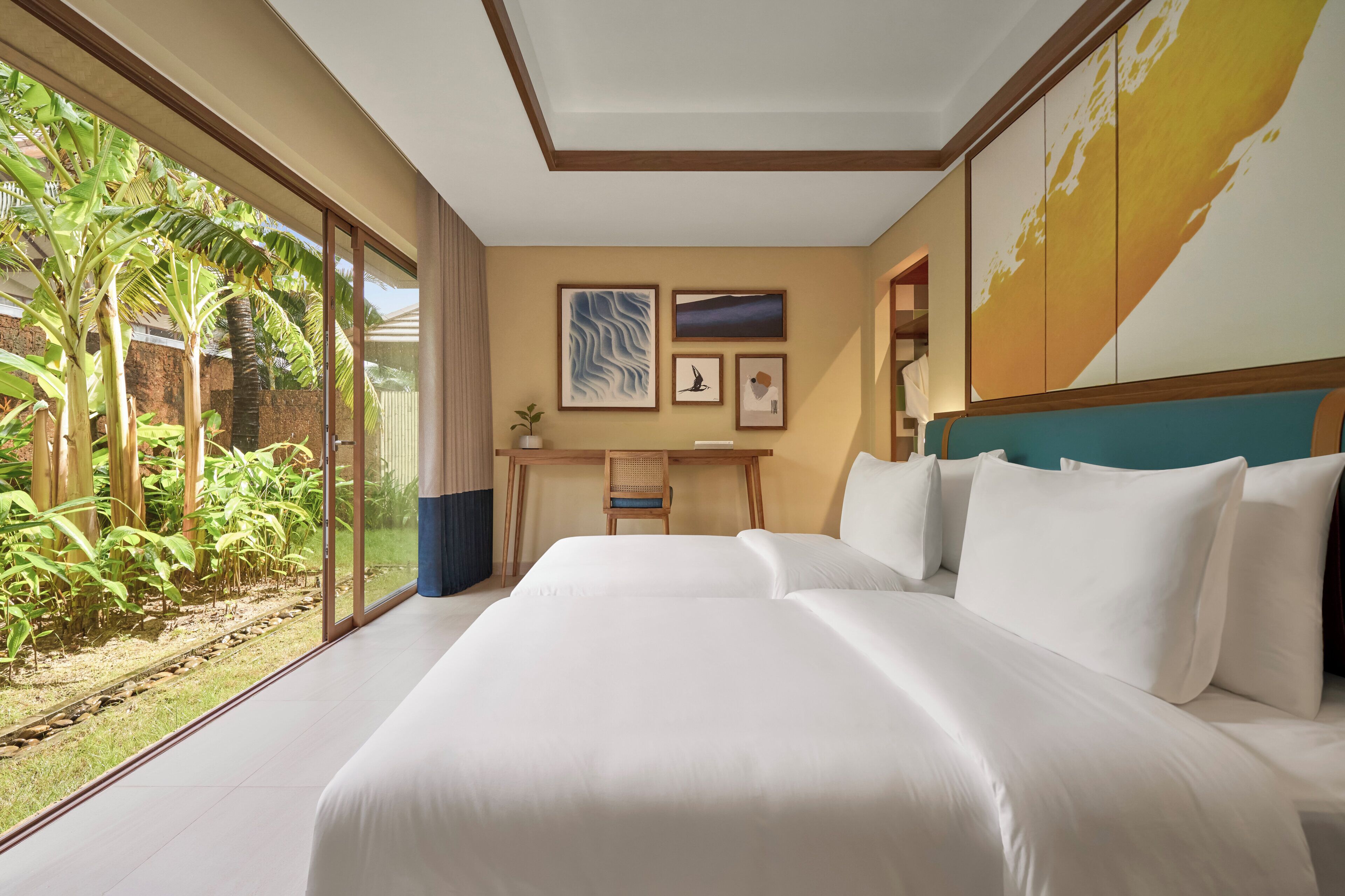 Habitación de hotel con una cama grande, un escritorio y vistas a un jardín.