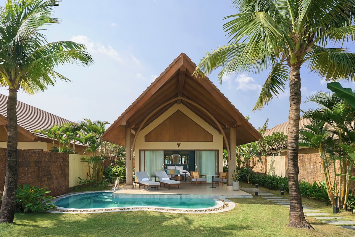 Un resort con piscina, sillas de descanso y una zona de estar techada.