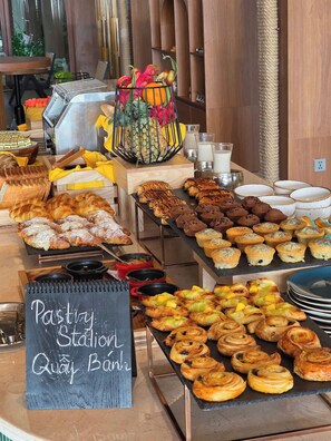 A bakery counter with various pastries and a sign reading "Pastry Station Quay Bank". - voco Quang Binh Resort by IHG (Dong Hoi)
