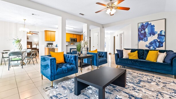 A spacious living room with a blue sofa set, a coffee table, and a ceiling fan. - 4 bedrooms, 2 bathrooms 
 (Dallas)