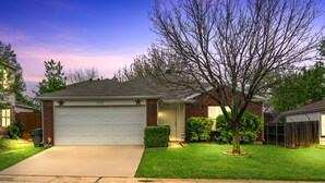 A residential house with a garage, a well-maintained lawn, and a tree in front. - 4 bedrooms, 2 bathrooms 
 (Dallas)