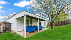 A covered patio with a white exterior, a concrete floor, and a blue outdoor seating area. - 4 bedrooms, 2 bathrooms 
 (Dallas)