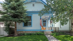 A light blue house with a gabled roof, a front porch with a wooden bench, and a small American flag. - Main Street Gem-Steps to Downtown Telluride (Telluride)