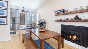 A modern kitchen with stainless steel appliances, a wooden dining table, and a fireplace. - Main Street Gem-Steps to Downtown Telluride (Telluride)