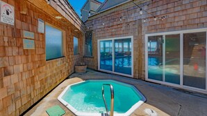 A wooden spa area with a 3ft deep pool, glass doors, and a sign prohibiting glassware.
