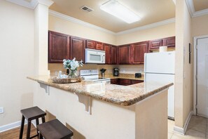 Enjoy cooking in this well-equipped kitchen with a central island, appliances, and ample workspace.