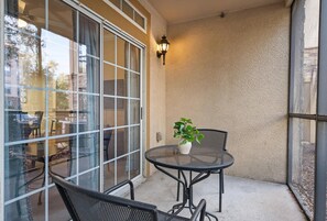 Enjoy a peaceful retreat with a patio featuring a table, chair, and lush greenery.