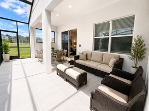A spacious patio with a dining area, a sofa set, and a potted plant. - Luxury 12 B.R 11.5BA 15 B.D in upscale community Pool/Game Close to Disney (Kissimmee)