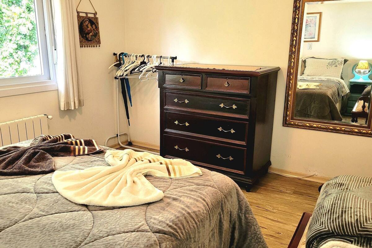 Ein Schlafzimmer mit Bett, Kommode und Spiegel.