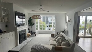 A spacious living room with a large sectional sofa, a fireplace, and a television.