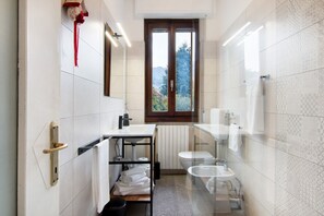 A modern bathroom with a toilet, sink, and window.