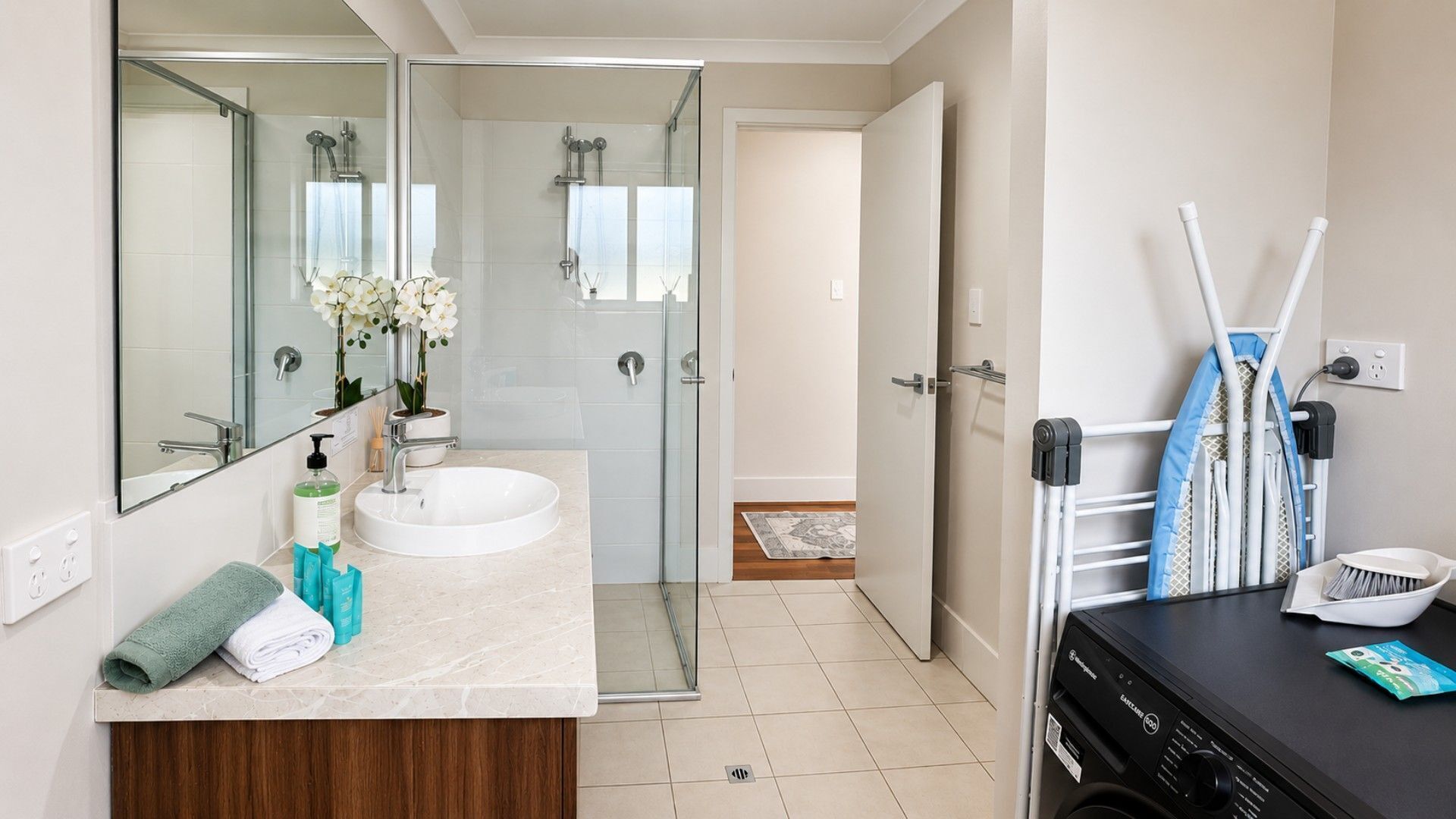 Un baño moderno con cabina de ducha de vidrio, un lavamanos y un espejo.