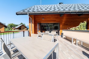 Un bâtiment en bois doté d’un balcon, d’un espace extérieur aménagé pour s’asseoir et offrant une vue sur les environs.