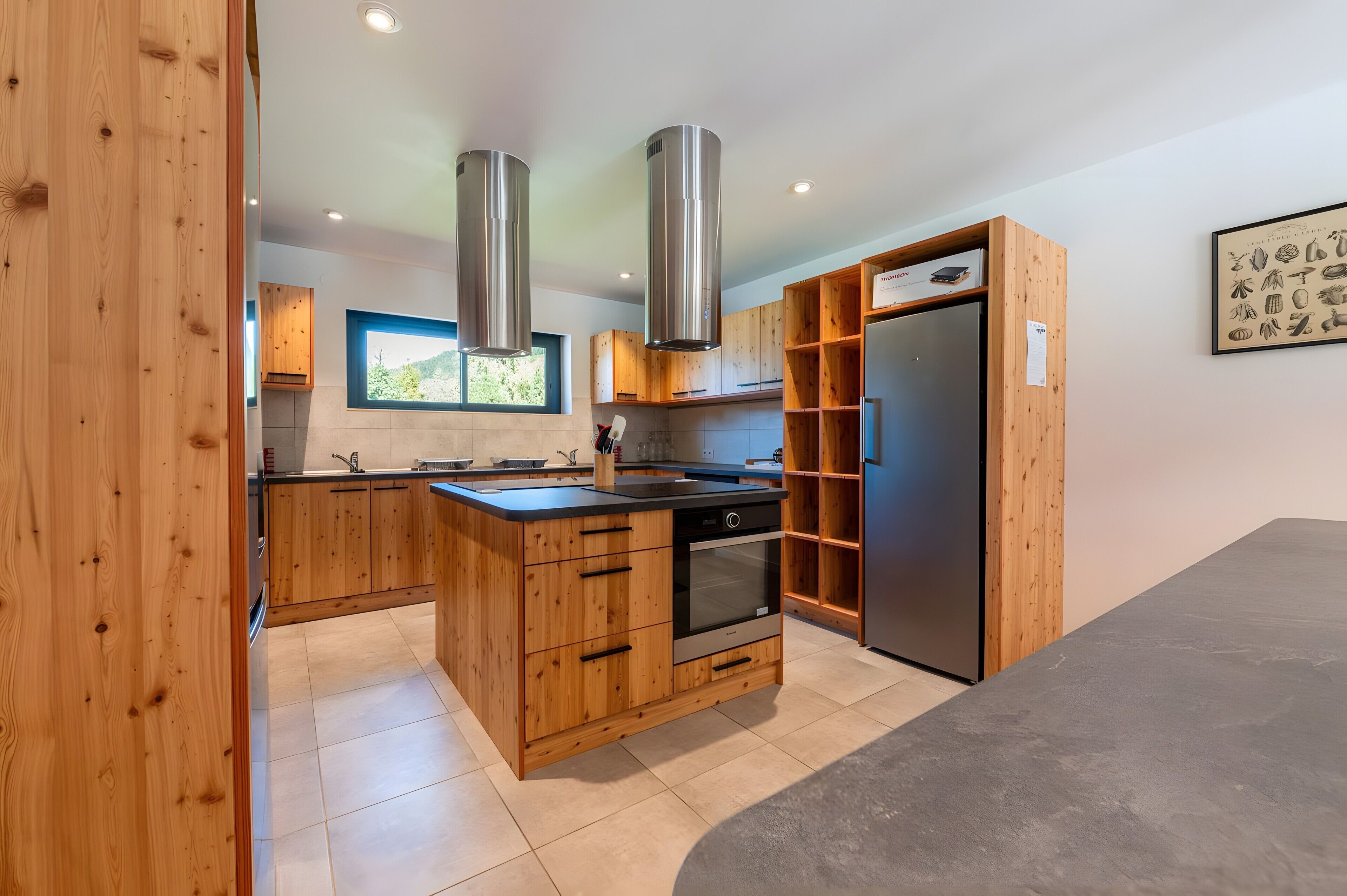 Een moderne keuken met houten kastjes, roestvrijstalen apparatuur en een inbouwoven.