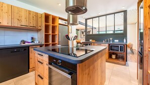 A modern kitchen with wooden cabinets, a built-in stove, and a microwave.