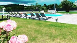 A poolside area with lounge chairs and a pool.