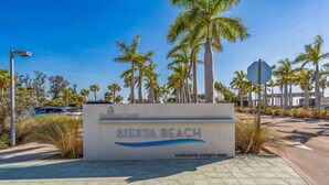 A sign for Siesta Beach, a Sarasota County park, with palm trees and a clear sky in the background. - Renovated 4BR Sarasota Home Private Heated Pool 28-Day Min Near Siesta Key (Sarasota)