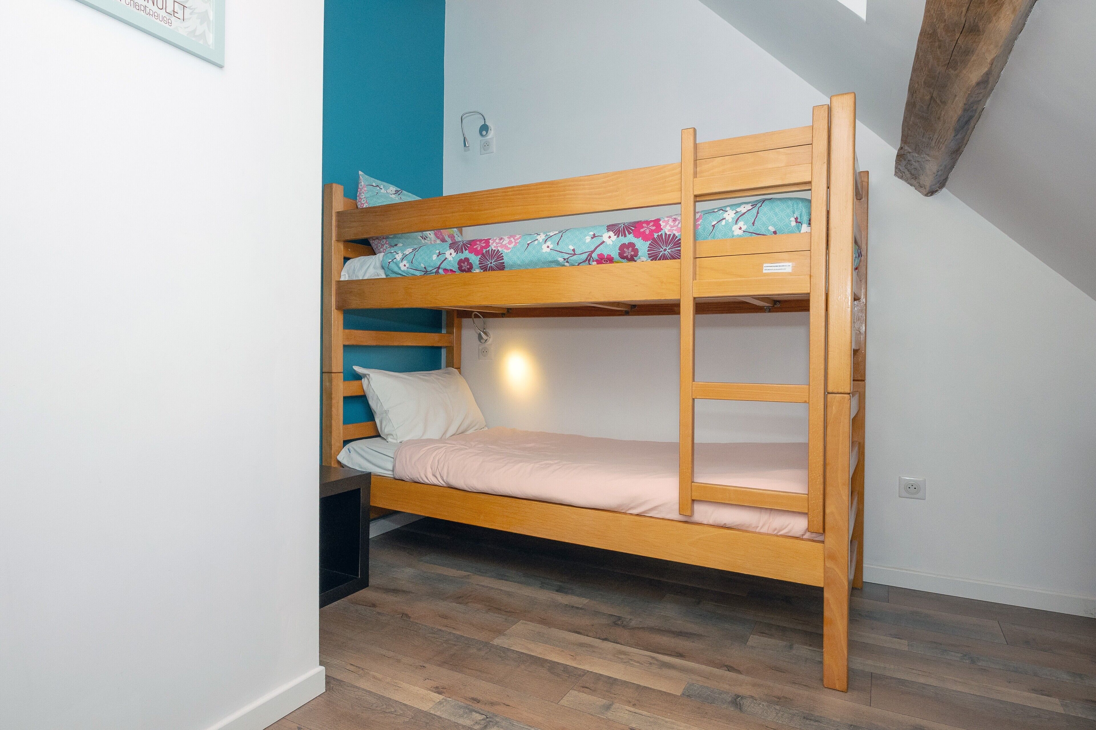 Ein Etagenbett mit Holzrahmen, Kissen und Decke.