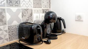 A kitchen with a toaster, a coffee maker, and a power strip on a countertop.