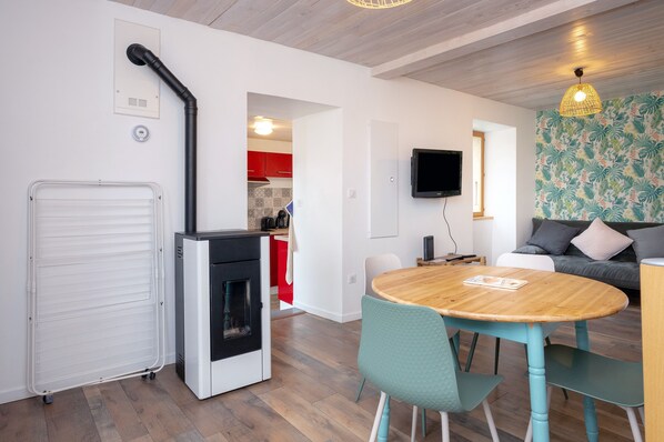 A modern living space with a kitchen, dining area, and seating area.