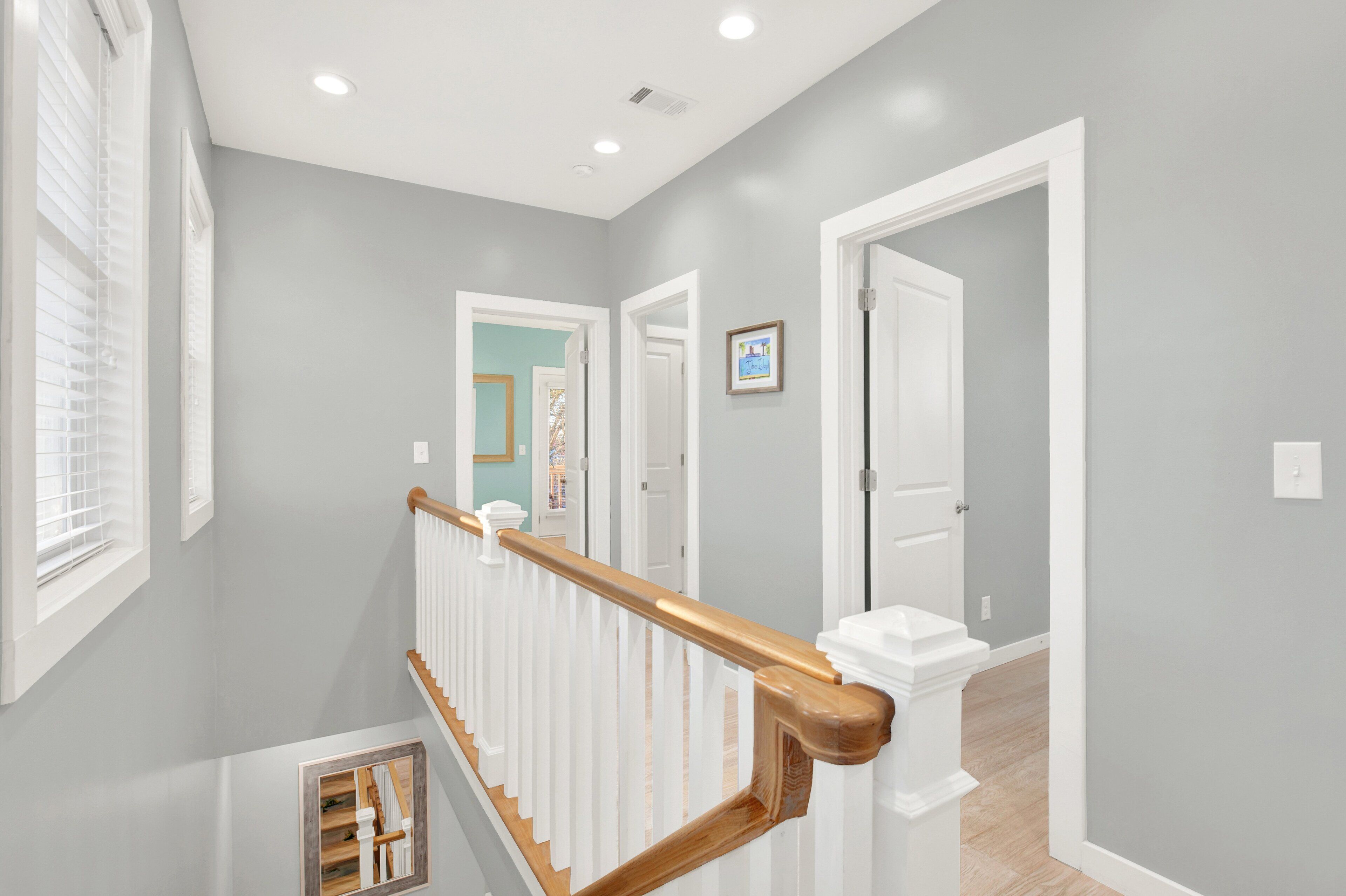 A modern interior with a staircase, white walls, and a door leading to another room.